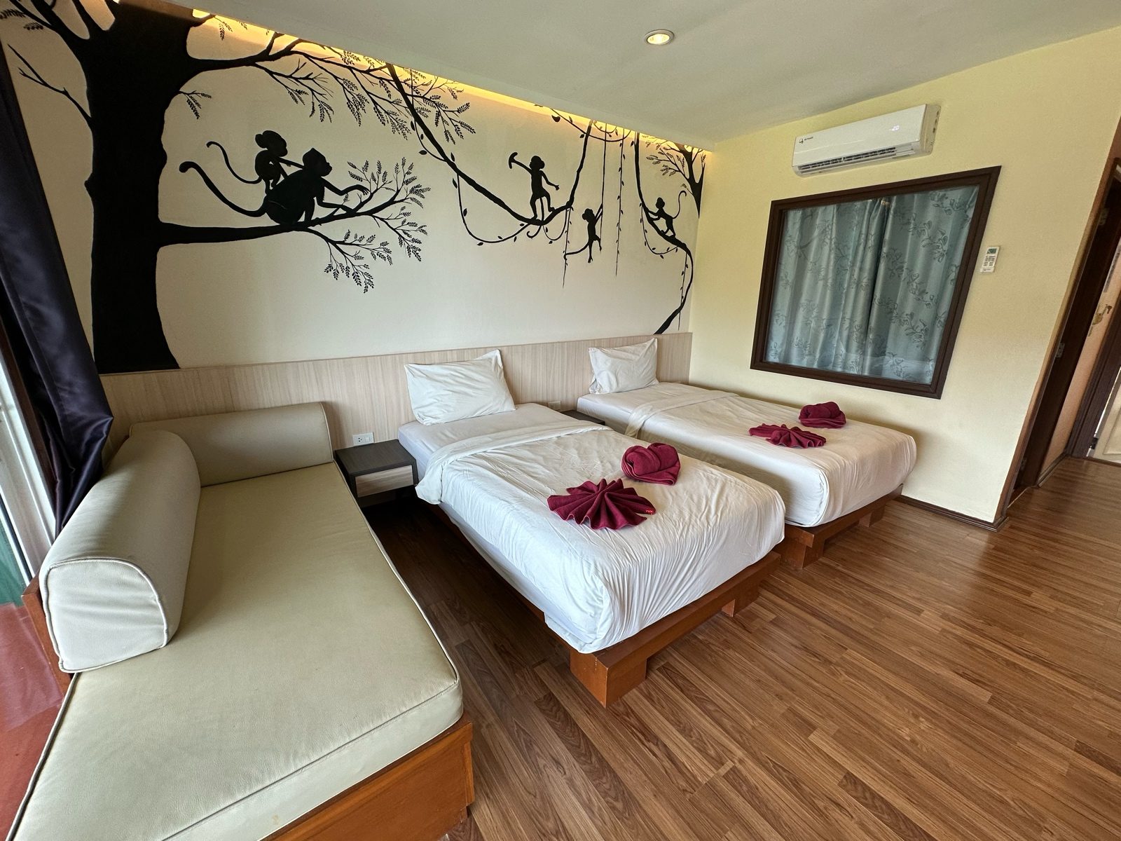 Before: a room with a daybed and twin beds, the wood floor grey and the linen slightly off-white.