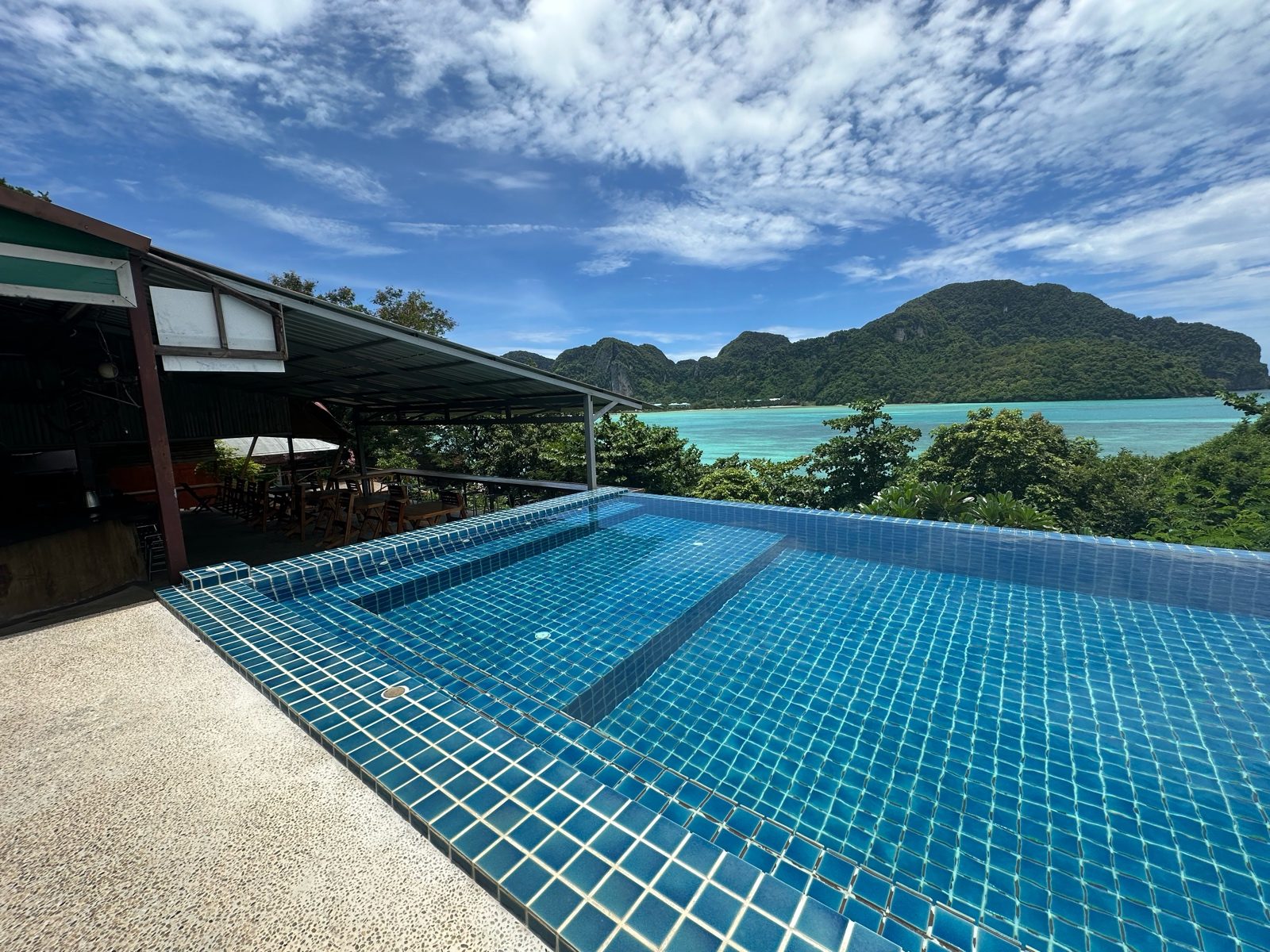 Infinity pool at a Phi Phi cottage looking over the bay, straight off the phone: pale sky, flat teal water.